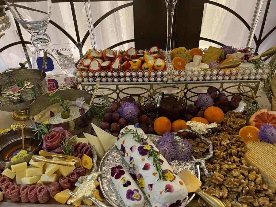Abundant L’Amore event table with cheese, charcuterie, fruit, and flowers