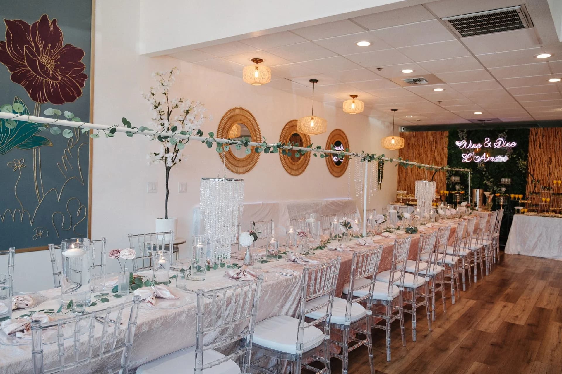 Wide view of the L’Amore private room with long blush tables and clear chairs