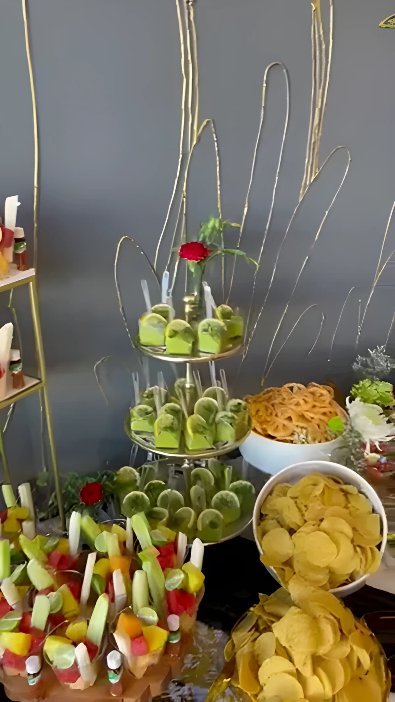 Fiesta appetizer table with fruit cups, cucumber rolls, chips, and small bites
