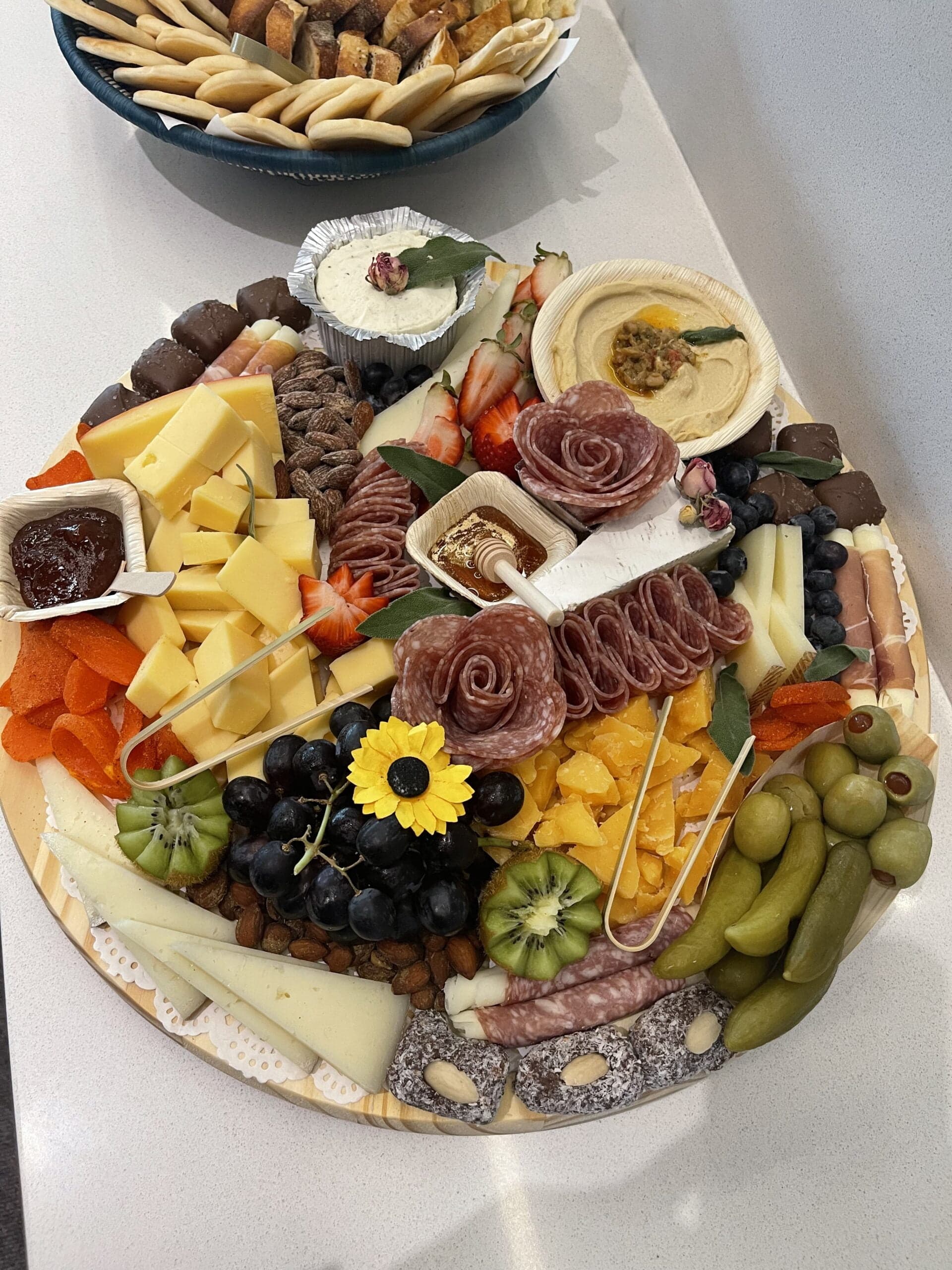 Round individual L’Amore grazing board with cheeses, meats, dips, and fruit