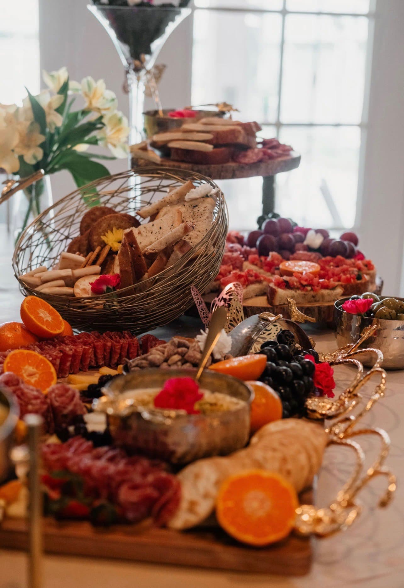Warm seasonal grazing table with citrus, florals, breads, and charcuterie
